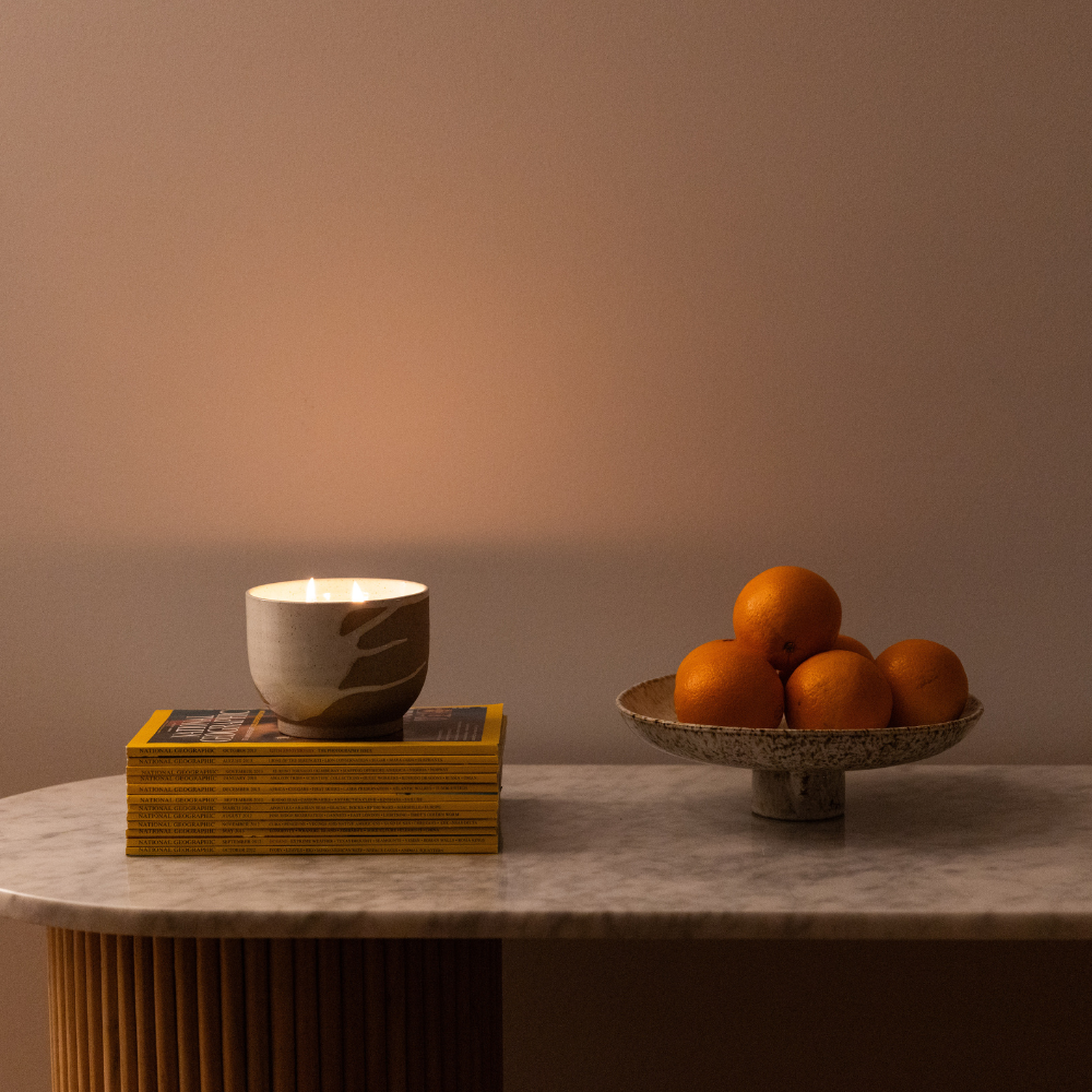 Soft candlelight from scented lunara candle styled on shelf