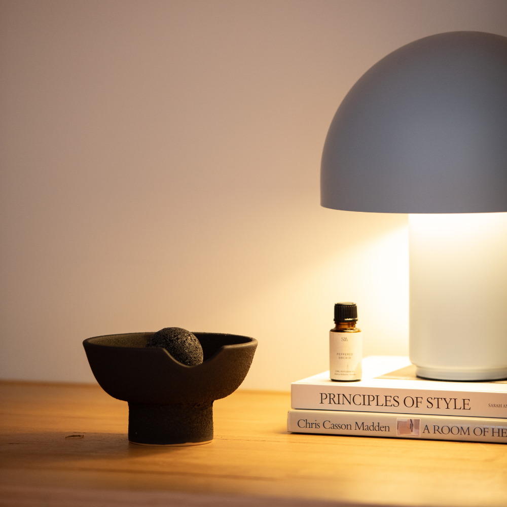 Obsidian ceramic diffuser styled on timber shelf alongside home décor accessories