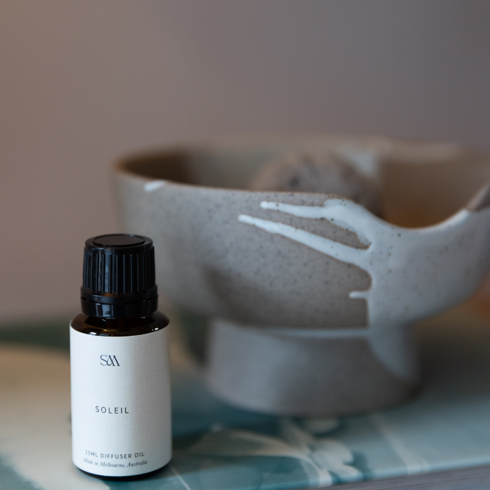 The soleil fragrance blend sitting next to ceramic lunara diffuser