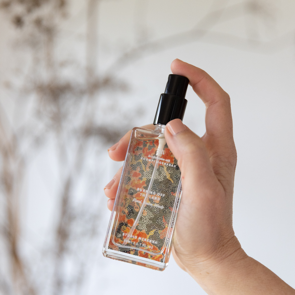 Burning Off The Land Interior Spray styled on natural timber surface with earthy tonal background