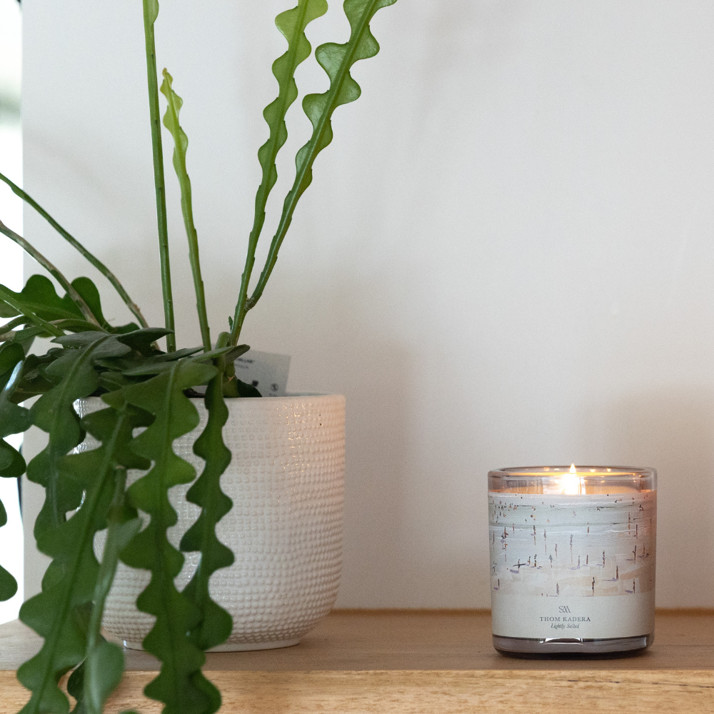 Close-up of Lightly Salted Candle showing Thom Kadera artwork label and ceramic vessel texture