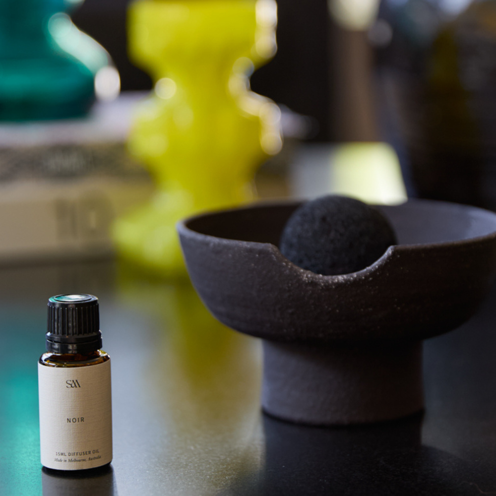 Noir Fragrance Oil styled on textured surface with soft lighting