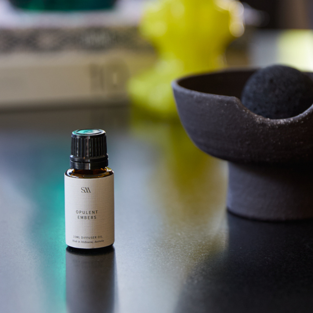 Opulent Embers Fragrance Oil styled on textured surface with soft lighting