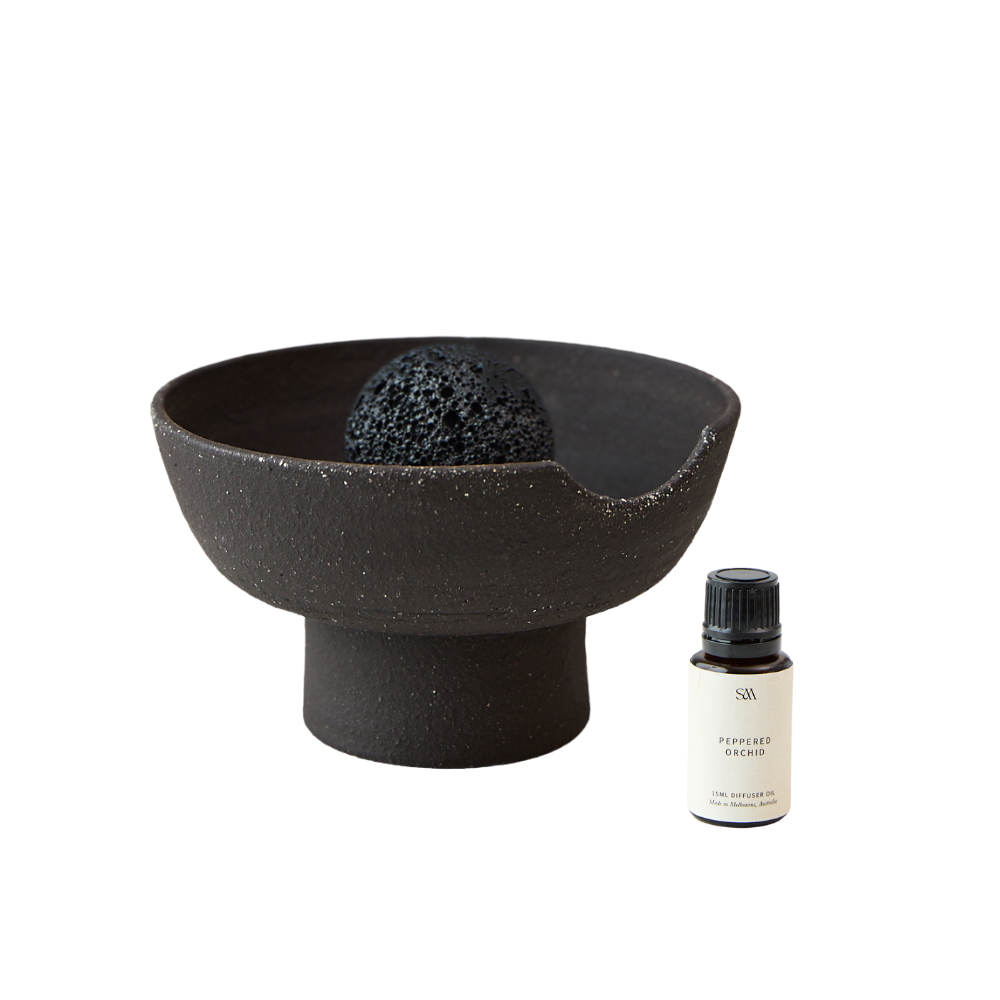 Studio McKenna Peppered Orchid Obsidian Diffuser flat lay with ceramic tray, volcanic rock, and fragrance oil bottle