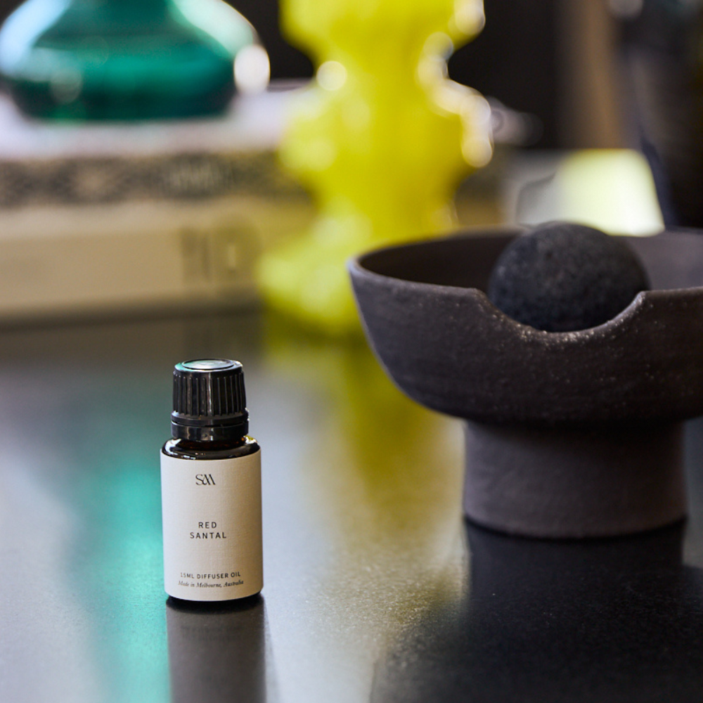 Red Santal Obsidian Fragrance Oil styled on textured surface with soft lighting