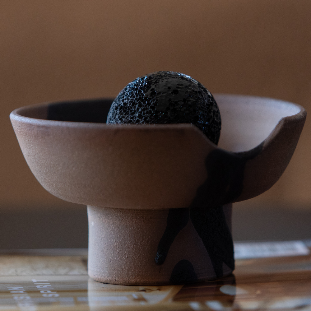 Close-up of Studio McKenna Volcanic Embers Lahar Diffuser showing volcanic rock and ceramic tray detail with textural glaze